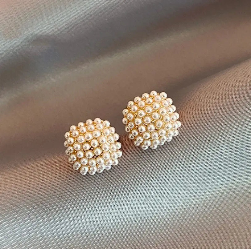 Elegant earrings with inlaid pearls in gold color