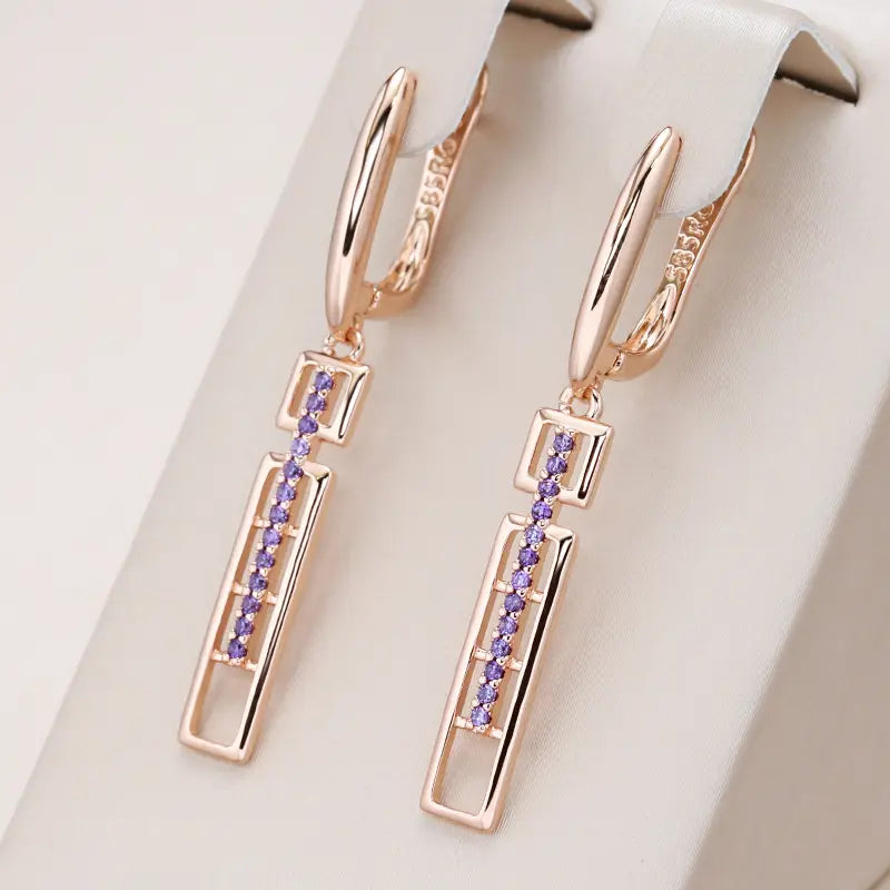 Elegant rectangular earrings with purple crystals in gold color