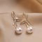 Gold pearl earrings with glittering bow