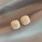 Elegant earrings with inlaid pearls in gold color
