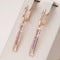 Elegant rectangular earrings with purple crystals in gold color